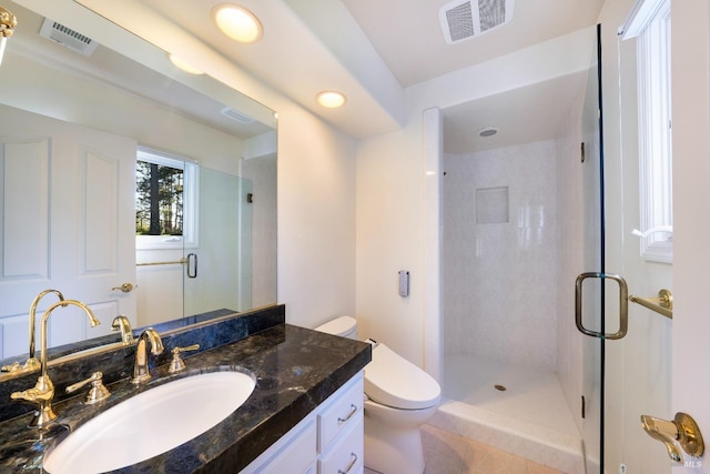 bathroom featuring toilet, vanity, a shower stall, and visible vents