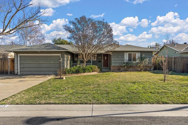 ranch-style house featuring a front lawn and a garage