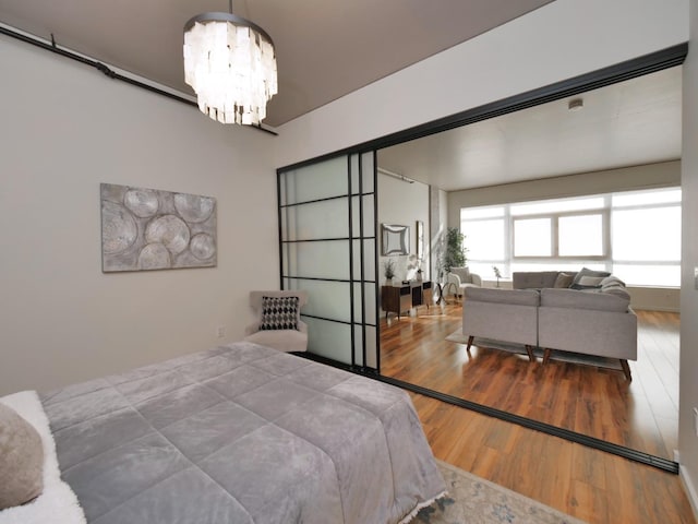 bedroom featuring wood-type flooring and an inviting chandelier