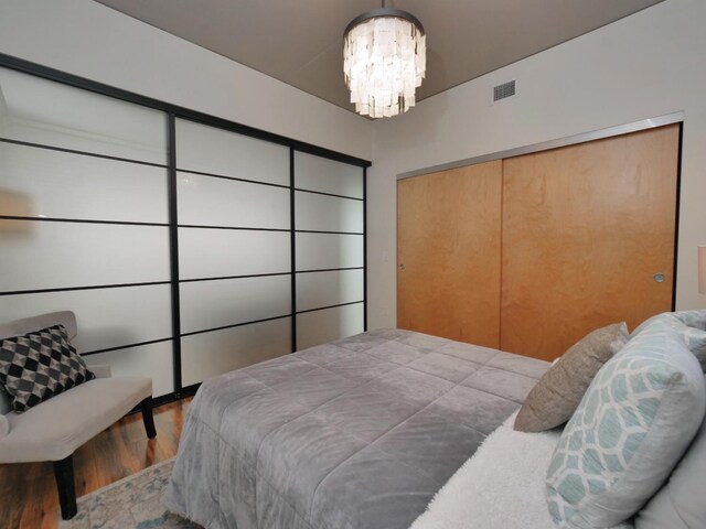 bedroom featuring hardwood / wood-style floors and an inviting chandelier