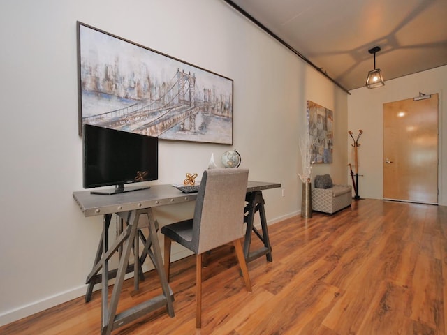 dining area with baseboards and wood finished floors