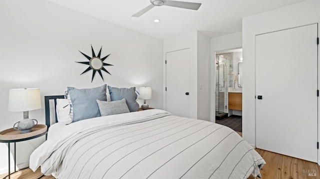 bedroom featuring recessed lighting, a ceiling fan, wood finished floors, and ensuite bathroom