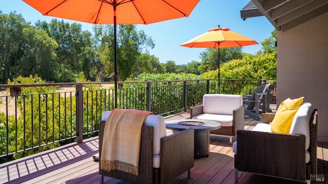 wooden terrace featuring an outdoor living space with a fire pit