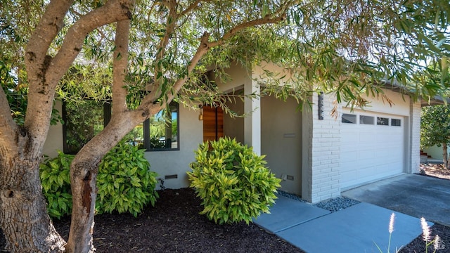 view of front facade with a garage, crawl space, concrete driveway, and brick siding