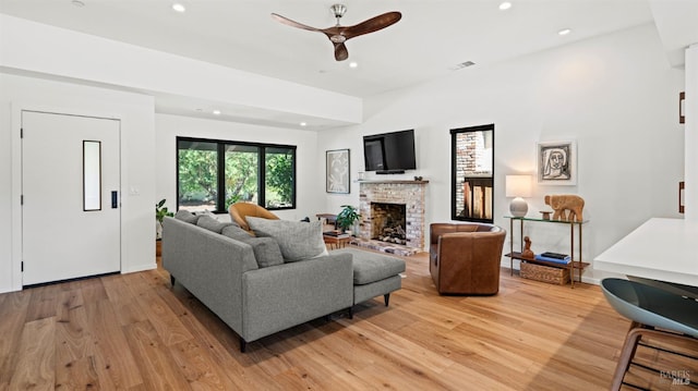 living room with recessed lighting, visible vents, light wood-style floors, a brick fireplace, and ceiling fan