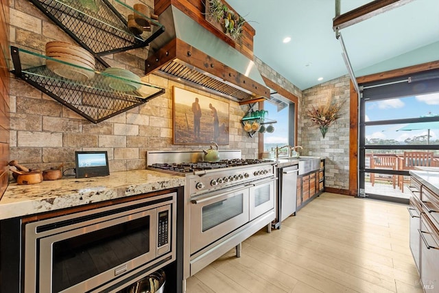 2135 E 2nd St, Benicia, CA 94510 - kitchen featuring light stone countertops, appliances with stainless steel finishes, range hood, backsplash, and light wood-type flooring