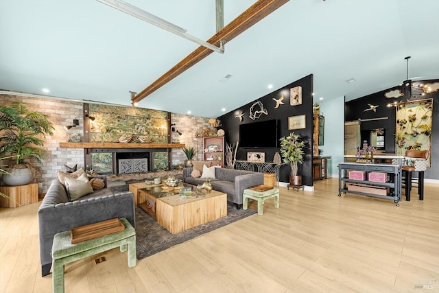 living area with high vaulted ceiling, a fireplace with raised hearth, and light wood-style flooring