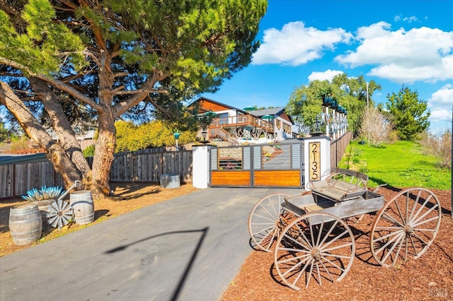 view of patio with driveway, fence, and a gate