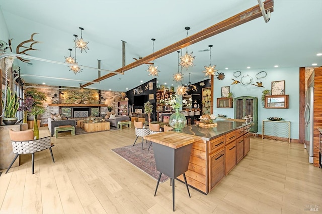 kitchen featuring pendant lighting, a fireplace, and light wood-style flooring