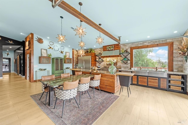 kitchen featuring light wood-type flooring, decorative backsplash, and stainless steel refrigerator