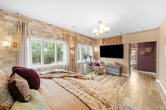 bedroom featuring baseboards, visible vents, an inviting chandelier, and wood finished floors