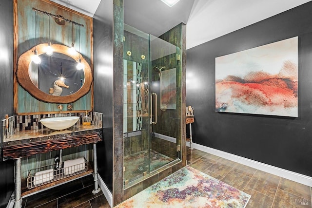 bathroom with a stall shower, vanity, and baseboards