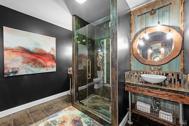 bathroom with baseboards, a sink, and a shower stall