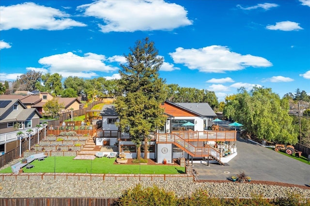 rear view of property featuring a fenced backyard, stairs, a yard, a wooden deck, and a patio area