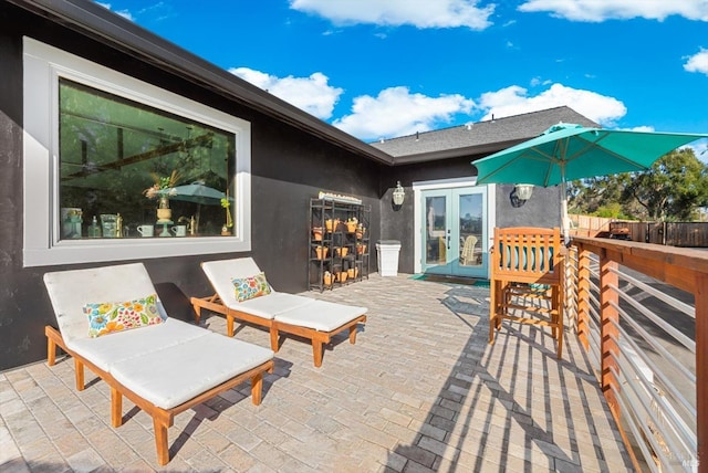 wooden terrace with a patio, french doors, and fence