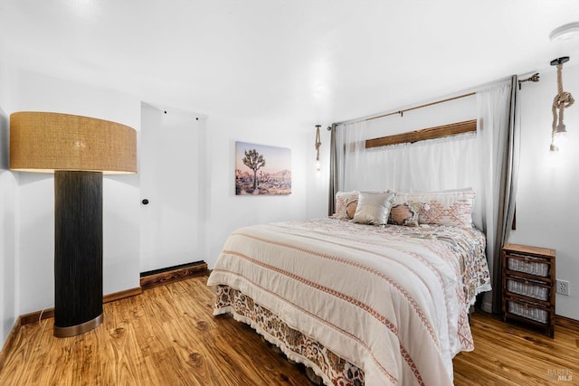 bedroom with wood finished floors and baseboards