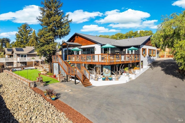 back of property with a yard, stairs, fence, a wooden deck, and a patio area