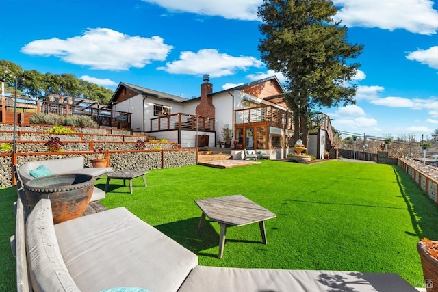 view of yard with fence, a patio, a balcony, and stairs