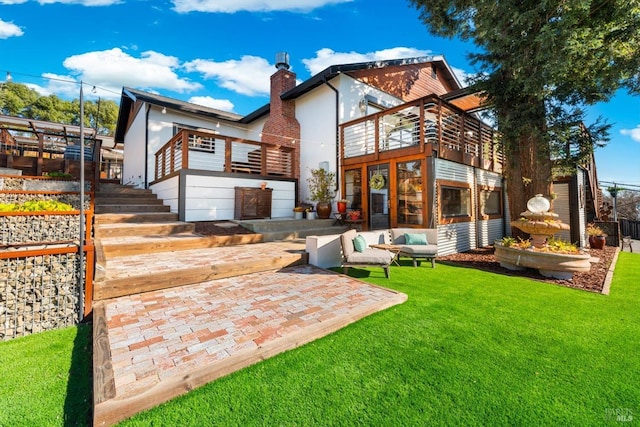 back of property with a yard, stairway, a chimney, and a patio area