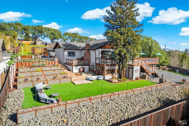 back of house with a vegetable garden, a lawn, a fenced backyard, a chimney, and stairway