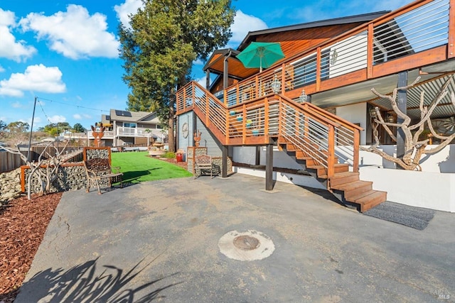 rear view of house featuring a patio area, a lawn, and stairway