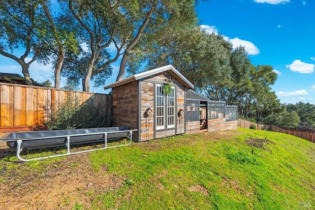 view of outdoor structure with a fenced backyard and an outbuilding