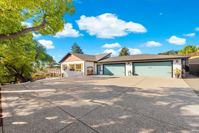 view of front of house with a garage, fence, and concrete driveway