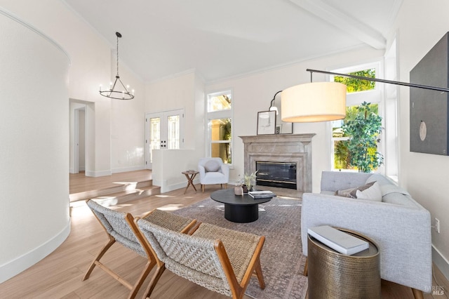 living room with high vaulted ceiling, a notable chandelier, a premium fireplace, wood finished floors, and baseboards