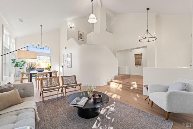 living room featuring a chandelier, ornamental molding, wood finished floors, and stairs