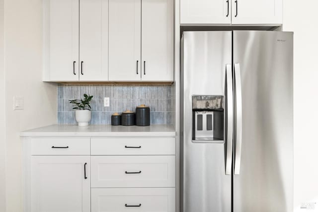 kitchen featuring white cabinets, tasteful backsplash, and stainless steel refrigerator with ice dispenser