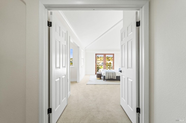 hall featuring light colored carpet and vaulted ceiling