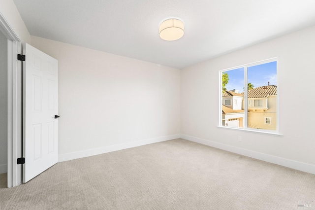 unfurnished room featuring carpet floors and baseboards