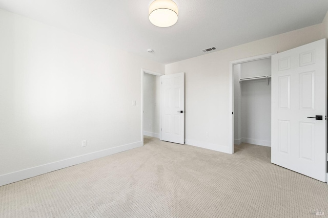 unfurnished bedroom with light colored carpet, a closet, visible vents, and baseboards