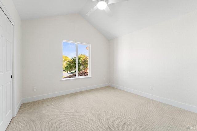 interior space with lofted ceiling, a closet, light carpet, and baseboards