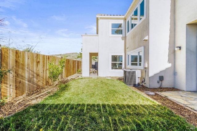 view of yard featuring central AC and a fenced backyard