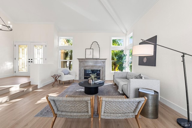 living room with vaulted ceiling with beams, light wood-style flooring, and baseboards