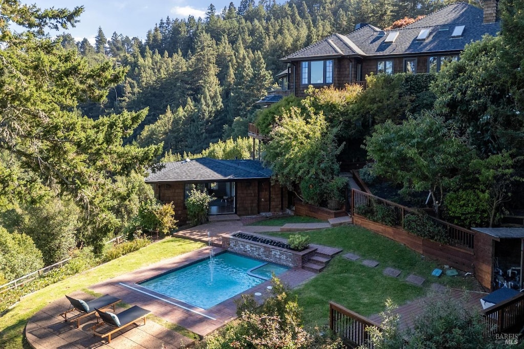 view of pool with a patio area, a lawn, and an outdoor structure