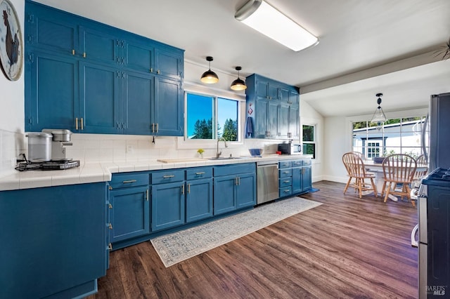 kitchen with appliances with stainless steel finishes, decorative backsplash, blue cabinetry, and hanging light fixtures