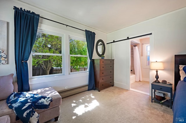 bedroom with baseboard heating, ensuite bathroom, a barn door, and carpet flooring