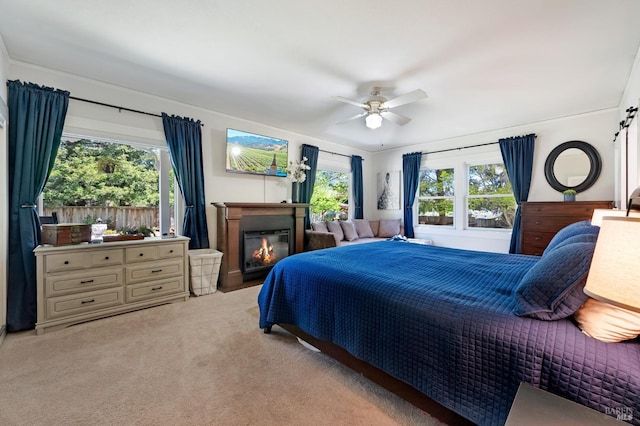 bedroom with light carpet, ceiling fan, and multiple windows