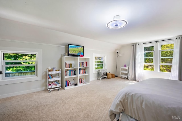 bedroom with lofted ceiling, light colored carpet, and multiple windows