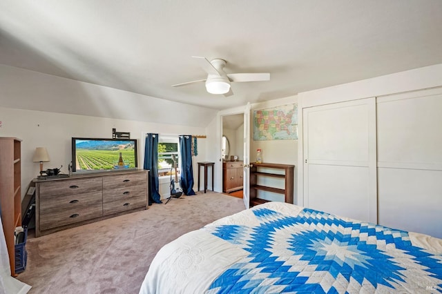 carpeted bedroom with vaulted ceiling, ceiling fan, and a closet