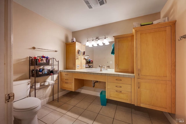 bathroom featuring toilet, tile patterned flooring, and vanity