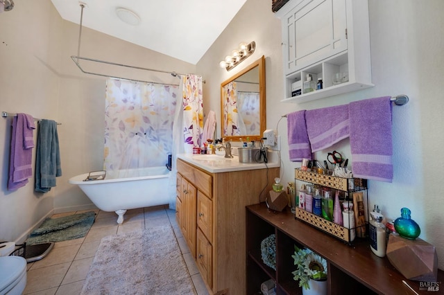 bathroom featuring tile patterned floors, vanity, toilet, and vaulted ceiling