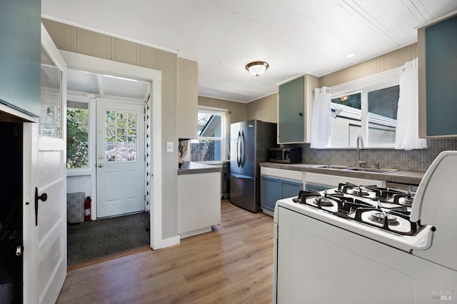 kitchen featuring light wood-type flooring, appliances with stainless steel finishes, backsplash, and sink