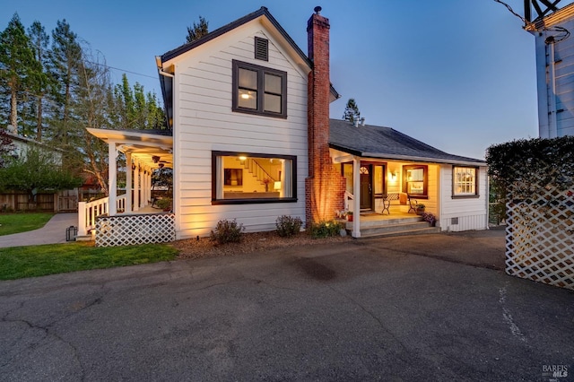 back house at dusk with covered porch