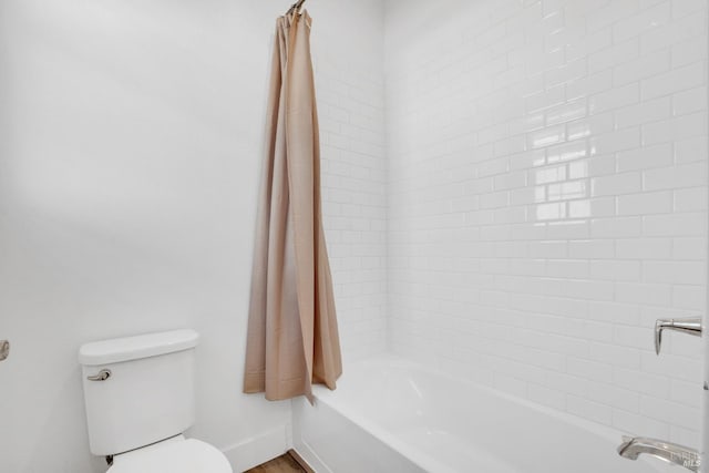 bathroom featuring toilet and shower / bath combo with shower curtain