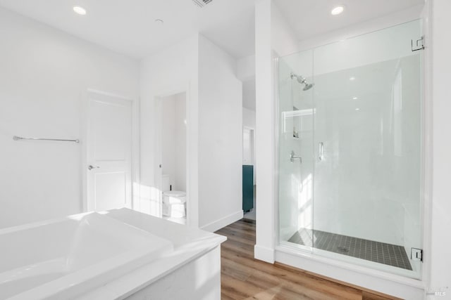 bathroom featuring wood-type flooring, toilet, and independent shower and bath