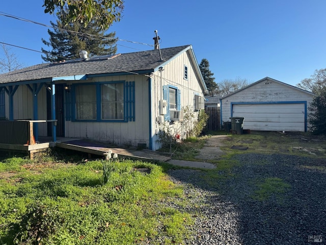 view of home's exterior featuring a garage, cooling unit, and an outdoor structure