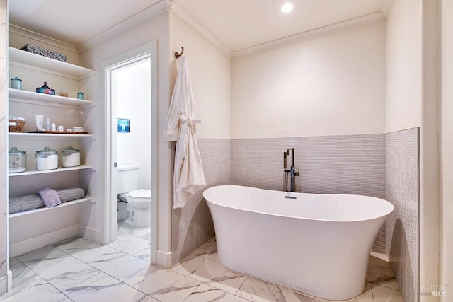 bathroom with crown molding, a tub to relax in, and toilet